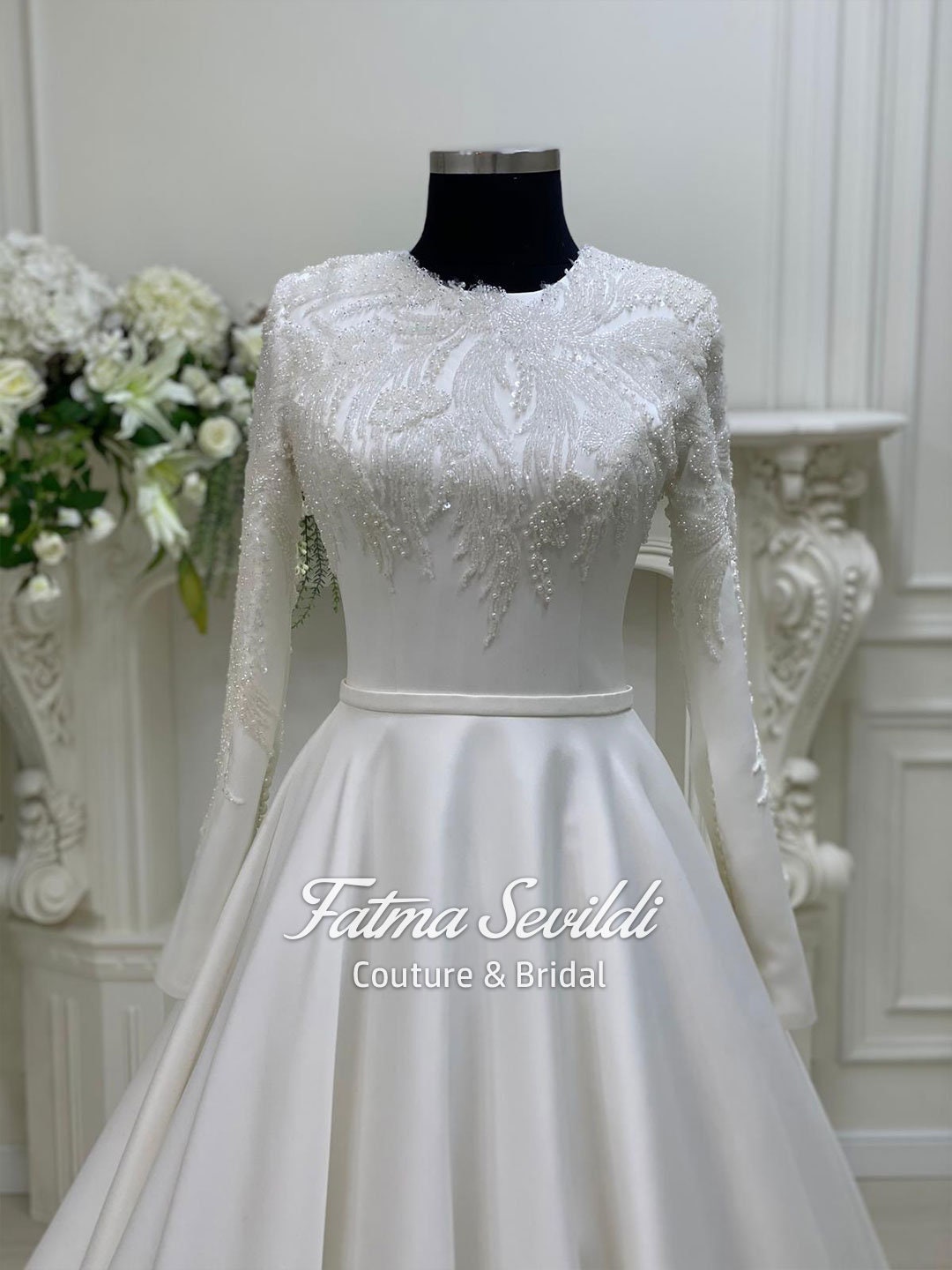 White satin modest long-sleeve A-line wedding dress with veil and silver beading