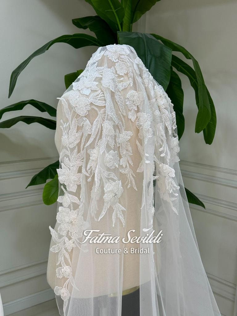 Delicate white lace bridal veil with floral appliques on Veiled Satin Hijab gown