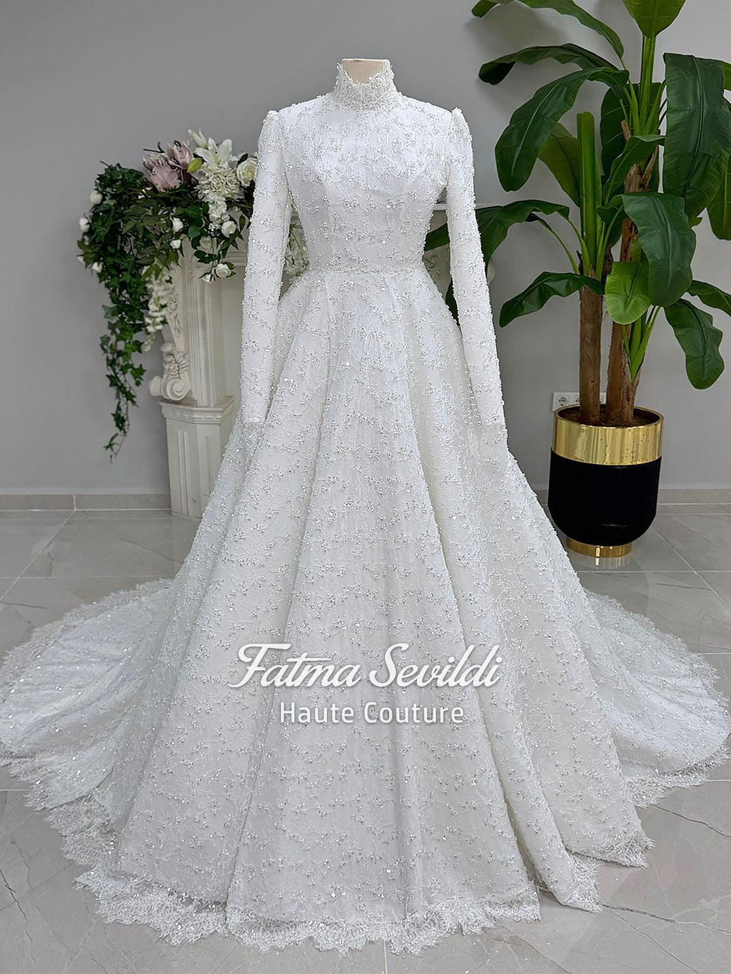 Elegant white long-sleeve Muslim bridal gown with beaded lace cape and high neck A-line design
