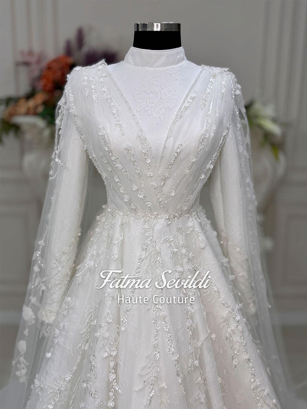 White long-sleeved modest bridal gown with floral lace, silver beading and veil