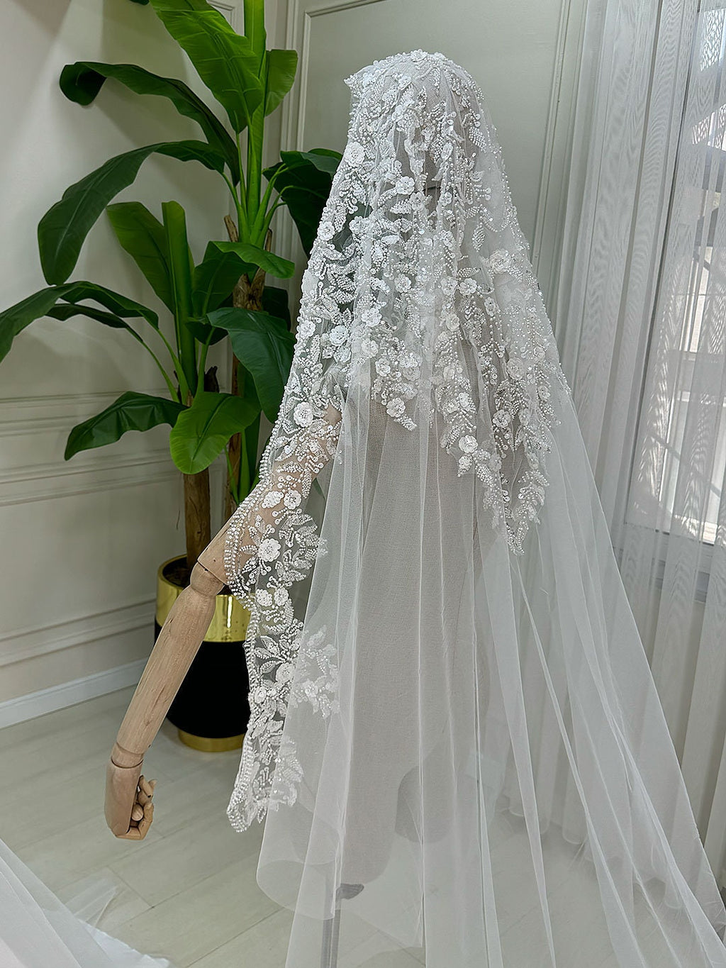 Delicate white lace bridal veil with floral embroidery on elegant A-line dress