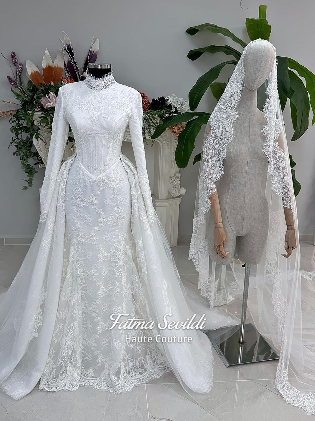 White hijab wedding dress with long sleeves, floral lace, high neckline and detachable overskirt, styled with a premium lace veil. Luxury modest bridal gown designed for a fully covered Muslim bridal look.