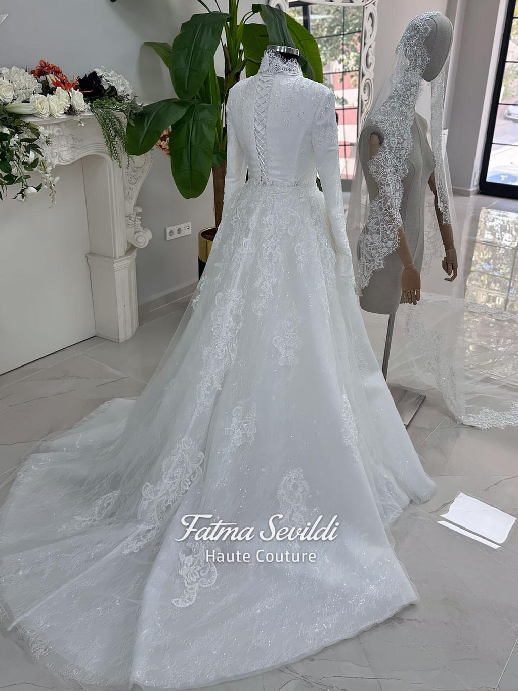 White hijab wedding dress with long sleeves, floral lace, high neckline and detachable overskirt, styled with a premium lace veil. Luxury modest bridal gown designed for a fully covered Muslim bridal look.