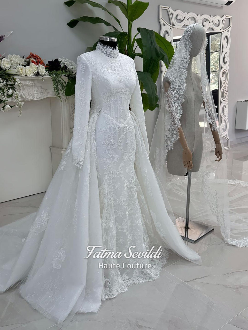 White hijab wedding dress with long sleeves, floral lace, high neckline and detachable overskirt, styled with a premium lace veil. Luxury modest bridal gown designed for a fully covered Muslim bridal look.