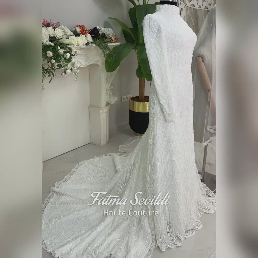 Luxury hijab wedding dress with long sleeves, high neck, beaded lace mermaid silhouette and detachable overskirt, veiled bridal set. Handmade couture modest bridal gown with lace-up corset back and sparkling embroidery.