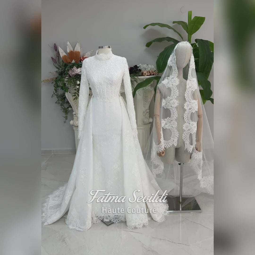 Luxury hijab wedding dress with long sleeves, high mock neck, floral lace embroidery, detachable mermaid skirt, dramatic train and premium lace veil for a modest Muslim bride.