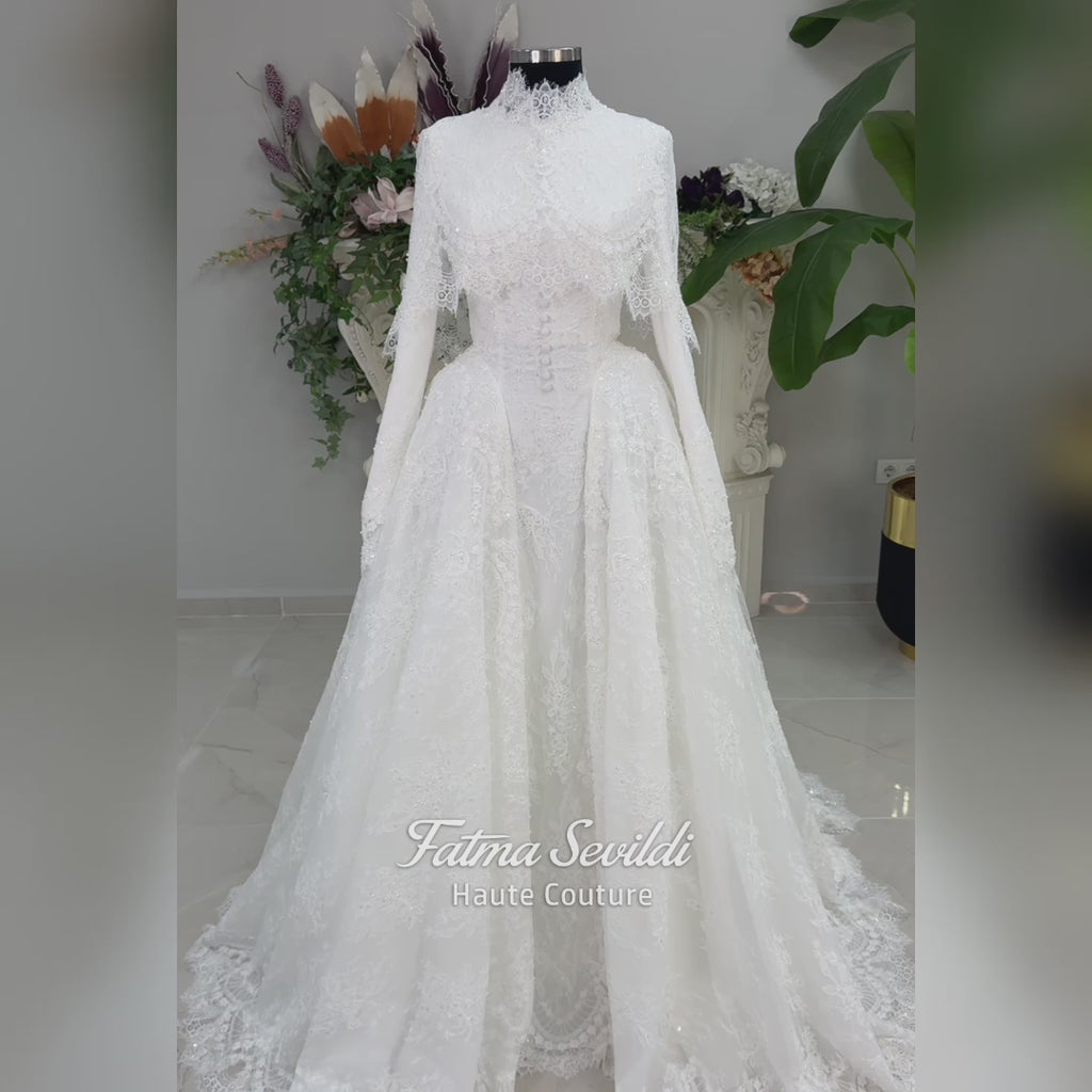 Off-white hijab wedding dress by Fatma Sevildi with beaded floral lace, a basque waist, long sleeves and a high neckline.