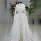 Off-white hijab wedding dress by Fatma Sevildi with beaded floral lace, a basque waist, long sleeves and a high neckline.